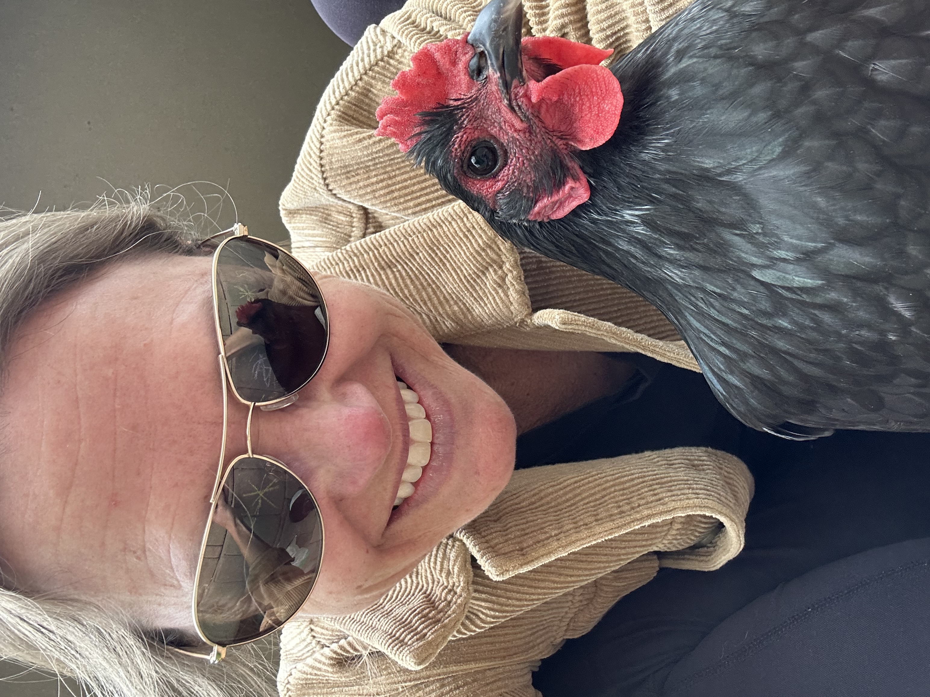 Blair smiling beside a black chicken